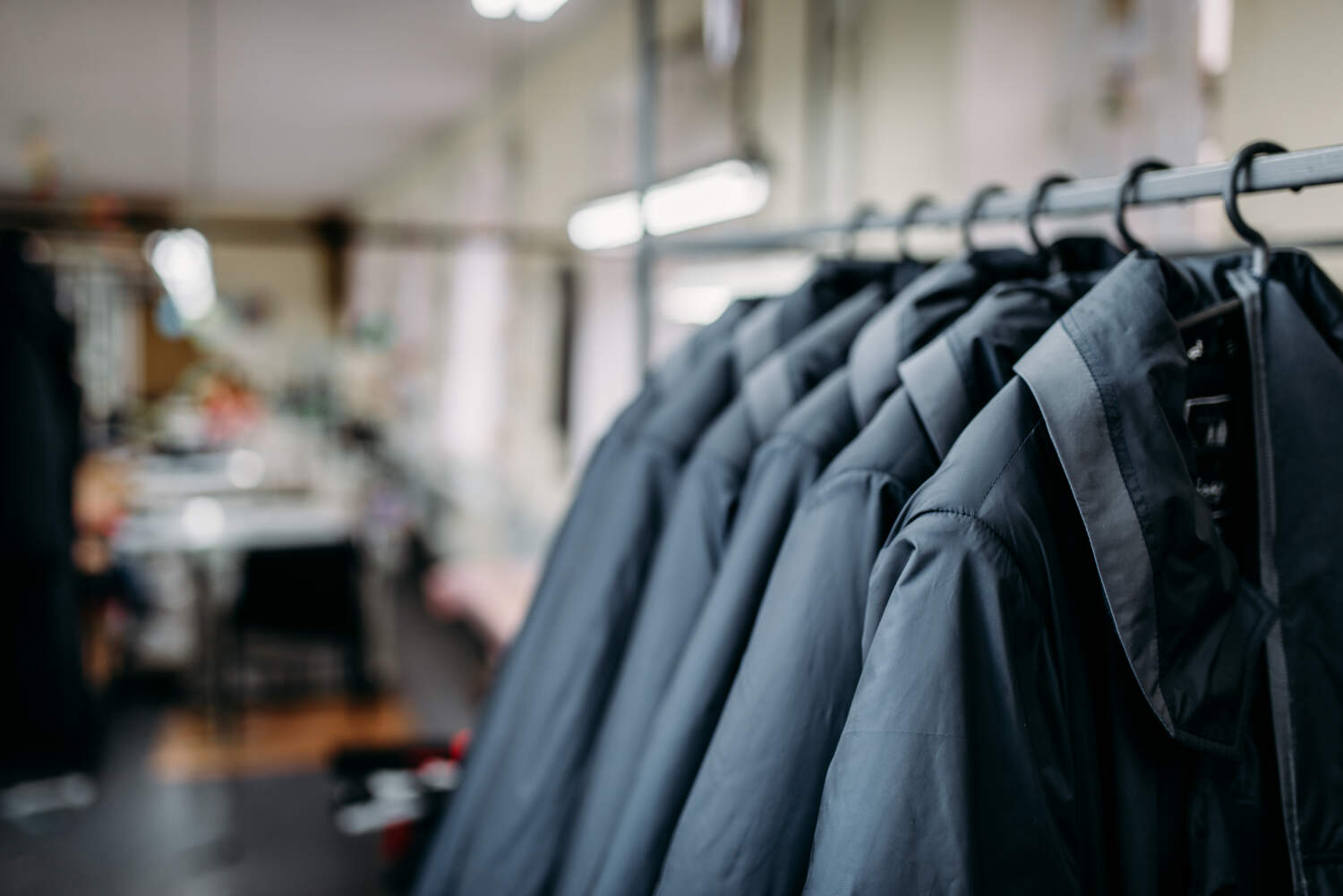 Row of jackets on a hangers, clothing store, sewing factory or dress fabric. Clothes on a racks